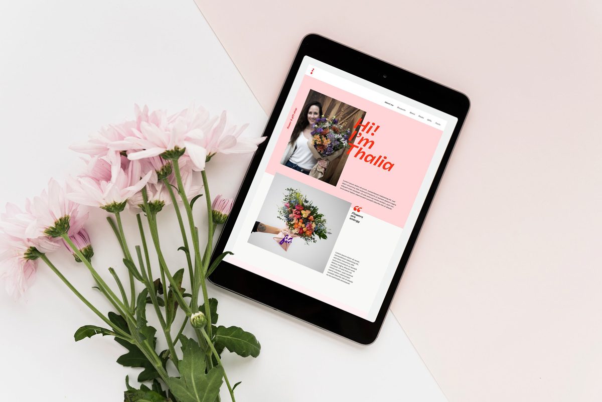 Isidora website on a tablet beside pink flowers