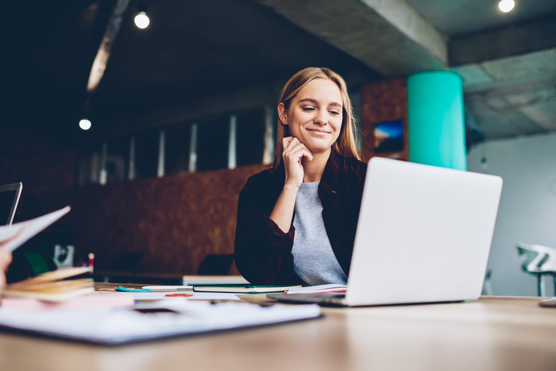 Customer smiling at a laptop in a bright office